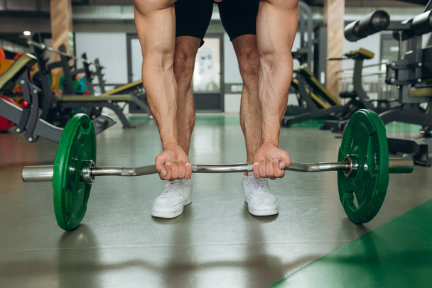 Close-up of man doing deadlift exercise at gym - Foto, afbeelding