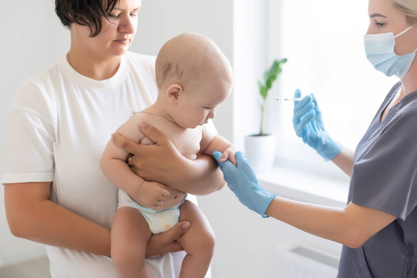Lékař provede očkování dítěte na bílém pozadí - Fotografie, Obrázek