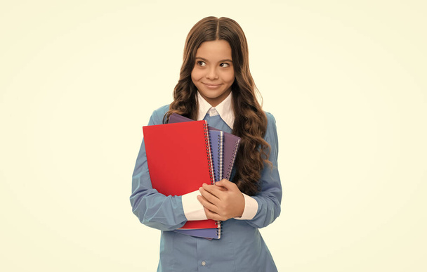 χαμογελαστό πορτρέτο παιδί έχει μακριά σγουρά μαλλιά με το βιβλίο εργασίας σχολείο απομονώνονται σε λευκό, σχολείο. - Φωτογραφία, εικόνα