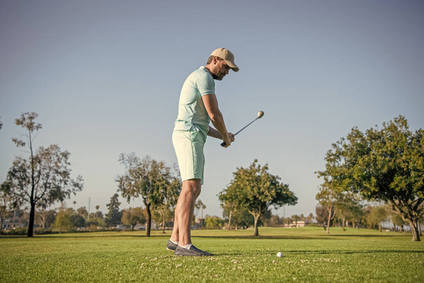 Pełna długość męski golfista na profesjonalnym polu z zieloną trawą, golf. - Zdjęcie, obraz