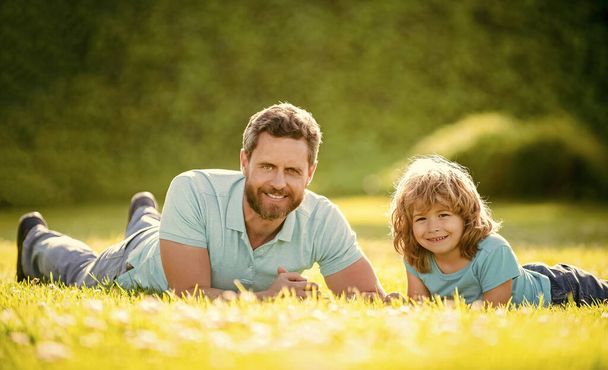 fathers day. happy father and son having fun in park. family value. childhood and parenthood. parent relax with little child boy on grass. dad with kid on summertime. parenting and fatherhood. - Photo, Image