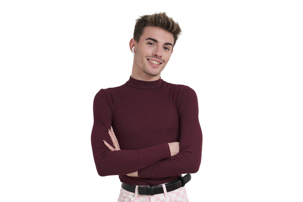 Young caucasian man smiling with his arms crossed and earphones, isolated on white background. - Foto, Imagen