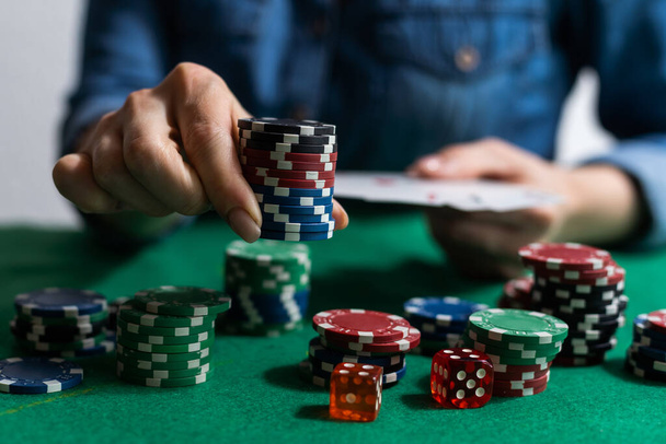 женская рука на зеленом покерном столе с фишками. - Фото, изображение