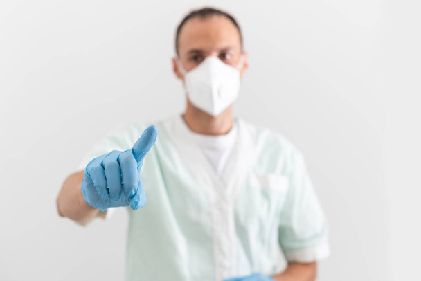 male doctor in white protective respirator close-up, concept of biohazard, emergency, SARS virus pandemic, COVID-19, coronavirus. - Photo, Image