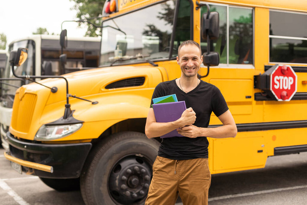Портрет учителя-мужчины возле школьного автобуса. - Фото, изображение