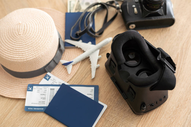Flat lay composition of vr headset, travel accessories on a wooden floor. Virtual Tourism. Top view - Photo, image