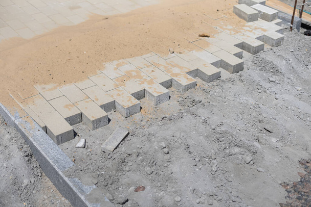 La colocación de bloques de piedra está en la base de arena. Dispositivo de acera
 - Foto, Imagen