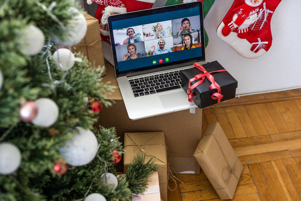 Щаслива сім'я з дитиною святкує Різдво зі своїми друзями на відеодзвінок за допомогою веб-камери. Сім'я вітає своїх родичів напередодні Різдва онлайн. Нова нормальна віртуальна подія
 - Фото, зображення