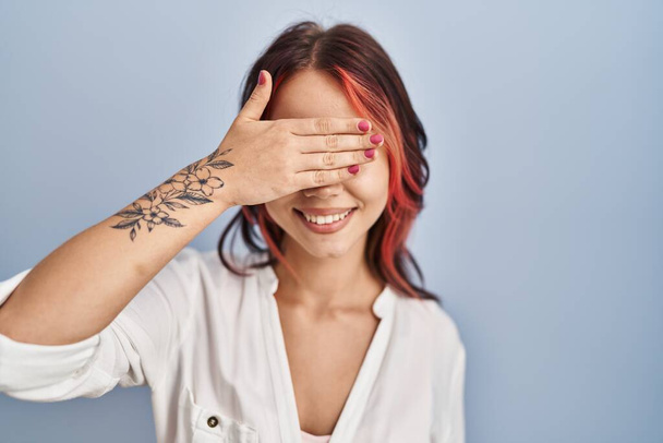 Young caucasian woman wearing casual white shirt over isolated background smiling and laughing with hand on face covering eyes for surprise. blind concept.  - Foto, Imagem