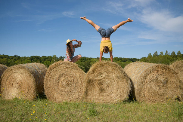 caucasian couple doing stunts on straw bales in France - Fotoğraf, Görsel