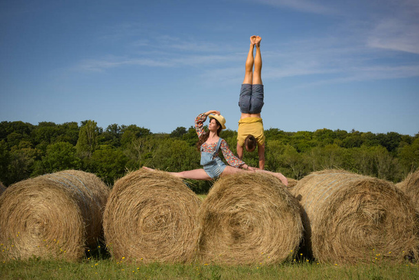 caucasian couple doing stunts on straw bales in France - Foto, Bild