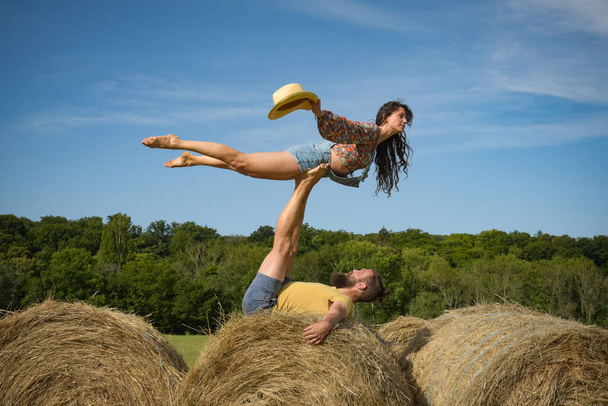 caucasian couple doing stunts on straw bales in France - Foto, Imagem