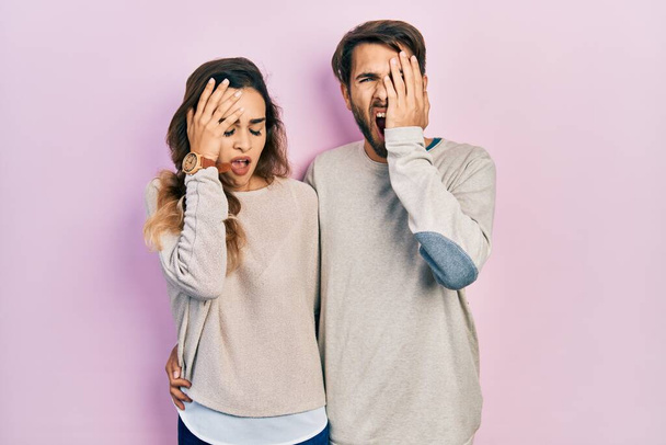 Young hispanic couple wearing casual clothes yawning tired covering half face, eye and mouth with hand. face hurts in pain.  - Foto, immagini