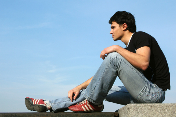 Teenager sitting on the stone blocks - Zdjęcie, obraz