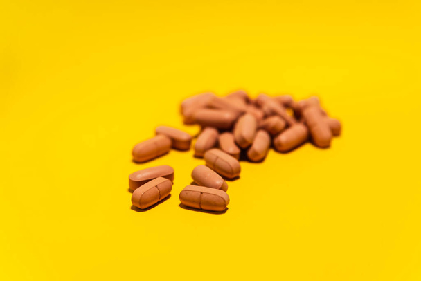Several brown colored pills laid out on top of a blue surface. Medical supplies. - Foto, afbeelding