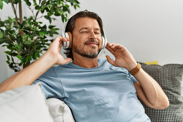 Middle age caucasian man smiling confident listening to music at home - Foto, Bild