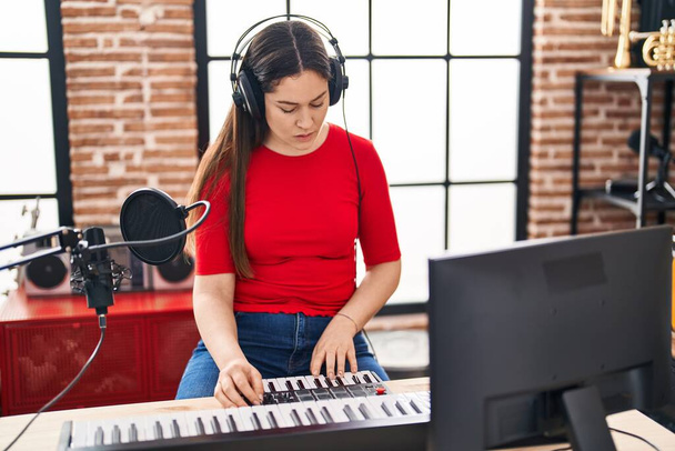 Jonge vrouw dj speelt muzieksessie in muziekstudio - Foto, afbeelding