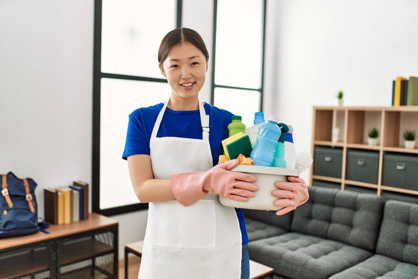 Mladá čínská hospodyňka drží čisticí prostředky stojící doma. - Fotografie, Obrázek