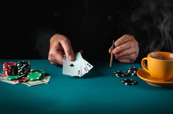 Playing cards with a winning combination in poker of three of a kind or set in the hand of a professional player. Success or fortune in the casino. - Foto, immagini