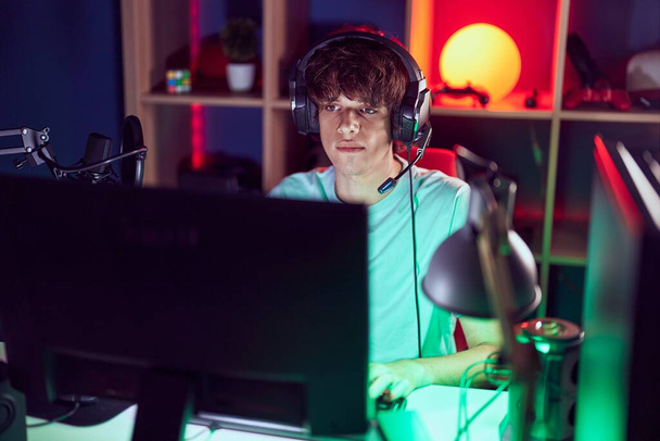 Mladý blond muž hraje videohry pomocí počítače v herně - Fotografie, Obrázek