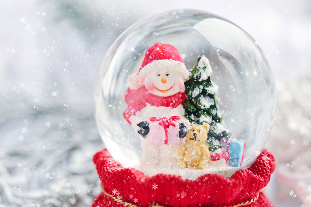 Una palla di neve con pupazzo di neve su sfondo festivo
 - Foto, immagini