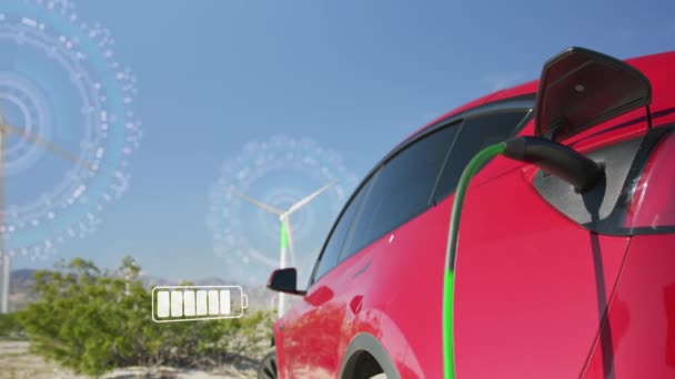 Red electric car charging on background of rotating windmills on sunny windy day. Charging electric car. Electric car charging on wind turbines generating renewable green energy, sustainable concept - Imágenes, Vídeo