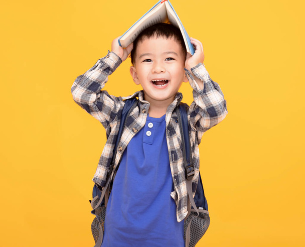 happy asian kid  holding book above his head - Foto, imagen