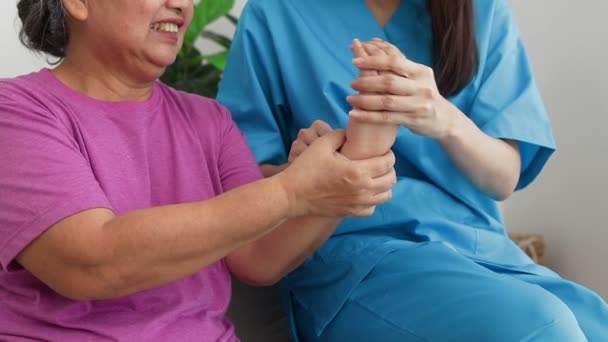 Female doctor doing physical therapy for elderly female patients. Handshake massage. Concept of medical services in hospitals. physical therapy center rejuvenate the elderly - Filmati, video