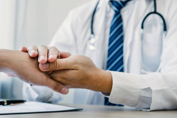 Les mains du médecin tenant la main du patient pour encourager et expliquer les résultats de l'examen de santé, concept de contrôle médical. - Photo, image