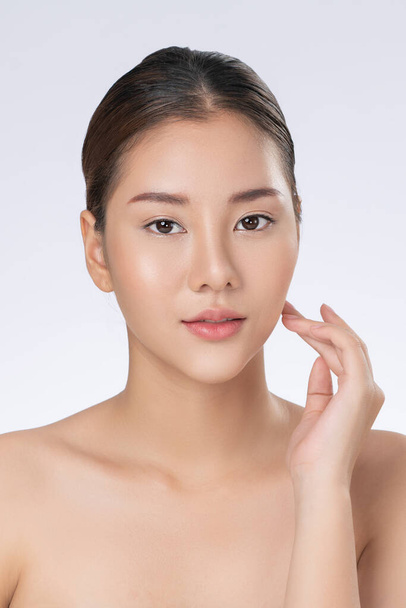 Portrait of gorgeous young girl posing beauty gesture with healthy clear skin and soft makeup. Cosmetology and beauty concept. - 写真・画像