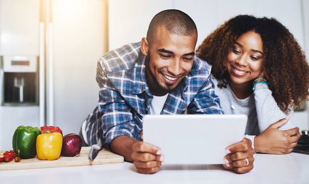 Looking up what to cook. a young couple using a tablet together at home - Photo, Image