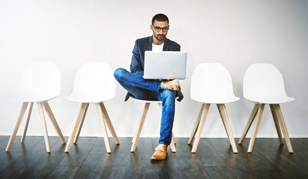 Использование Интернета, чтобы сделать некоторые исследования о компании. молодой бизнесмен с ноутбуком во время ожидания в очереди - Фото, изображение