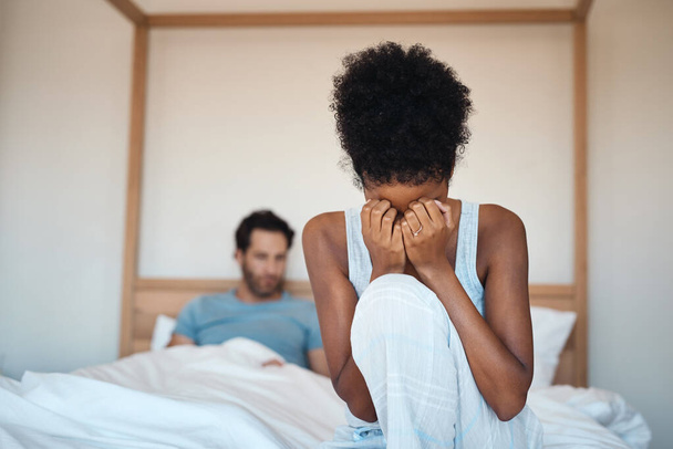 Woman crying after fighting with husband in bedroom at home. Wife sad after husbands affair, lies and cheating in the bed. Depressed couple having relationship problems and decide to get a divorce. - Foto, Imagem