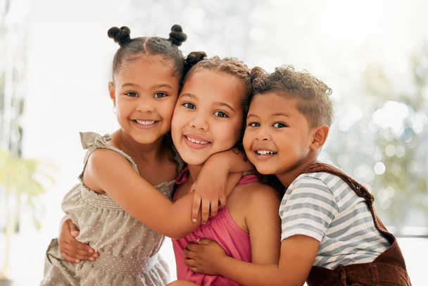 Siblings, boy and girl children hugging and bonding together as a cute happy family indoors during summer. Portrait of young, brother and sister kids smiling, embracing and enjoying their childhood. - Photo, image