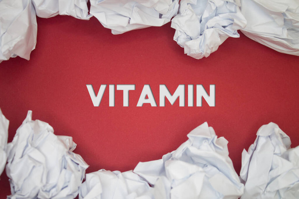 Vitamin text with Torn, Crumpled White Paper on colored background. - Foto, imagen