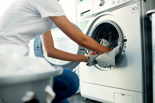 Μέρα πλυντηρίου έρχεται γύρω από μία φορά την εβδομάδα. Μια νεαρή γυναίκα πλένει τα ρούχα της στο σπίτι. - Φωτογραφία, εικόνα