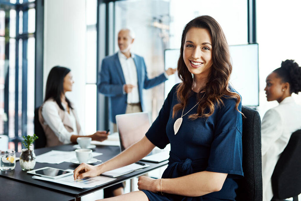 Corporate manager feeling positive about the leadership in a meeting conference. Confident female office worker or businesswoman sitting in a boardroom presentation with her colleagues - Photo, image