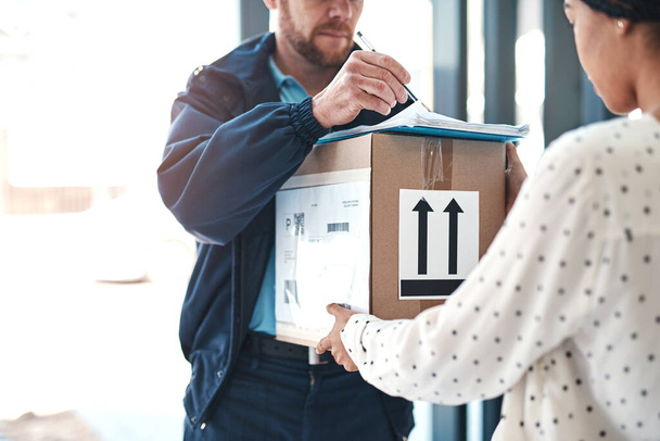 This where youll need to sign. an unrecognizable delivery man handing a package to a female customer - Foto, Imagem
