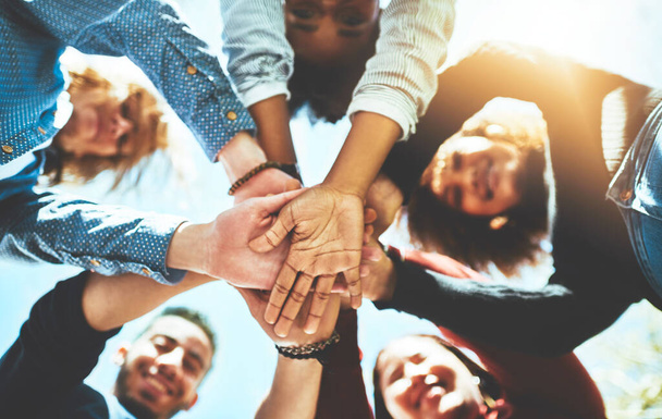 You can achieve a lot more as a team. High angle portrait of a diverse group of college friends standing outside with their hands in a huddle - Foto, Imagen