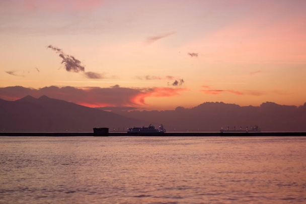Sunset over the mountains and the coast - bay of Aegean Sea in Izmir, Turkey with copy space - 写真・画像