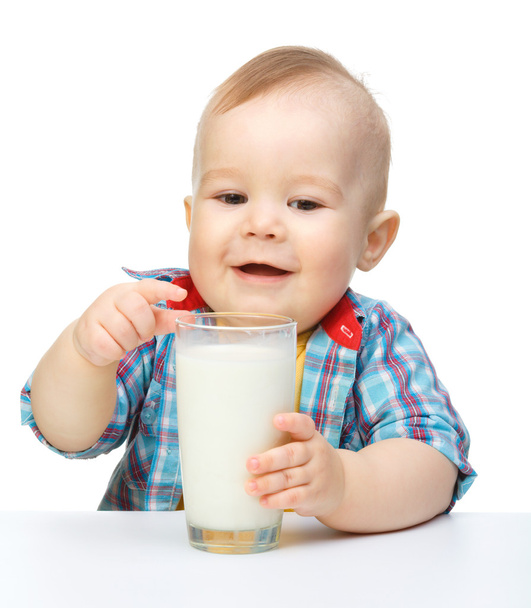 Cute little boy is holding big glass of milk - Fotoğraf, Görsel