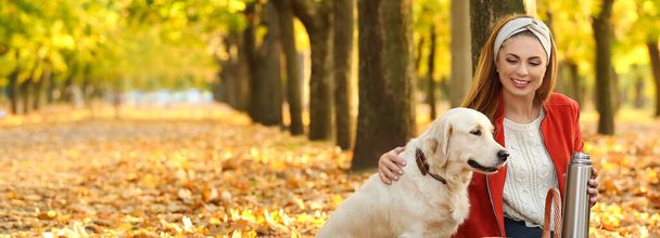 Happy woman with her cute dog in autumn park - 写真・画像