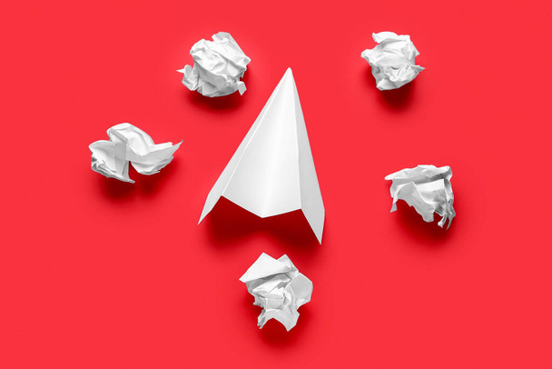 Crumpled paper and plane on red background - Photo, image
