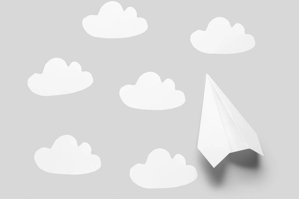 Επίπεδο χαρτιού και σύννεφα σε γκρι φόντο - Φωτογραφία, εικόνα