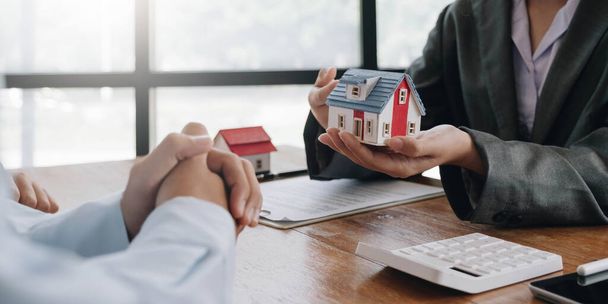Real estate agent talked about the terms of the home purchase agreement and asked the customer to sign the documents to make the contract legally, Home sales and home insurance concept - 写真・画像
