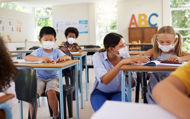 Covid learning with teacher and school students having lesson, study and education in class during pandemic. Educator helping, showing and talking to young kindergarten, preschool and elementary kids. - Foto, Imagem