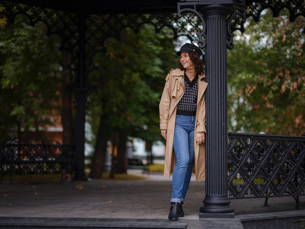 Young beautiful woman in autumn street. Young hispanic or Armenian woman wearing elegant style standing at the Moscow city park. - Foto, afbeelding