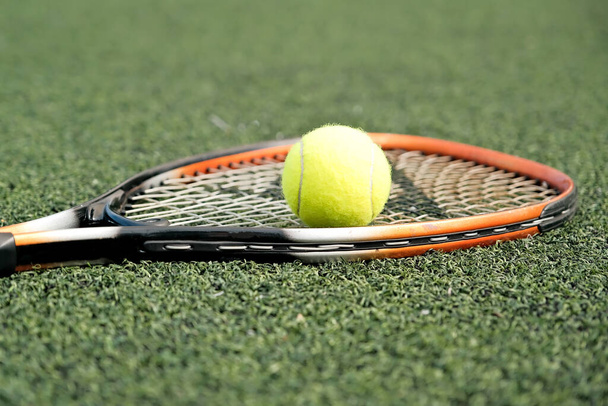 ball and tennis racket close-up. ball and racket on the tennis court. - Photo, image