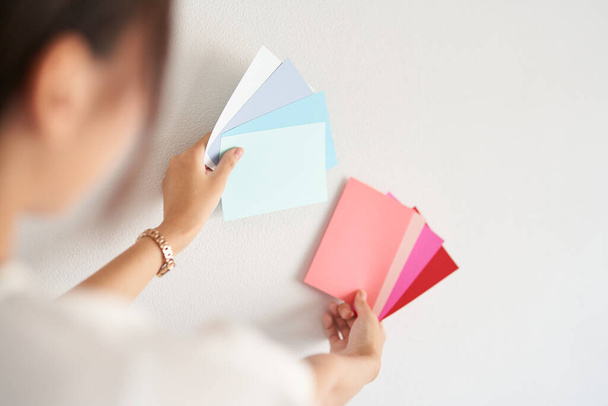 female interior coordinator considering wall color - Foto, Imagem