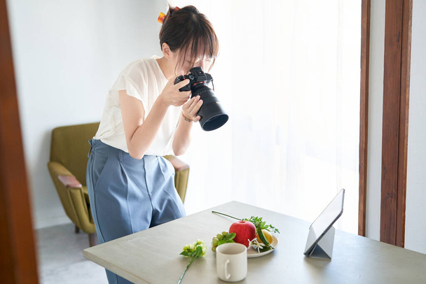 female photographer shooting in the room - Fotó, kép